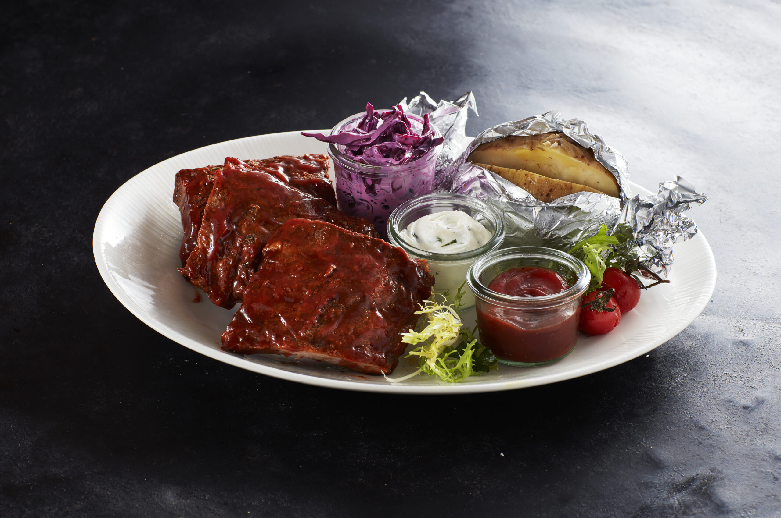 Spare ribs with BBQ sauce, baked potato and coleslaw
